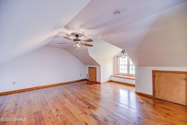 bonus room with light wood-style flooring, lofted ceiling, baseboards, and a ceiling fan