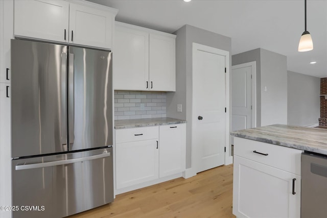 92 Valley View Rd, Lewisburg, PA 17837 - kitchen with freestanding refrigerator, light stone counters, light wood finished floors, white cabinetry, and decorative backsplash