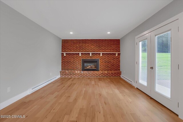 92 Valley View Rd, Lewisburg, PA 17837 - unfurnished living room featuring a baseboard heating unit, a fireplace, light wood finished floors, baseboard heating, and baseboards