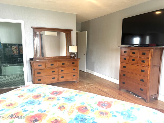 735 E 3rd St, Bloomsburg, PA 17815 - bedroom featuring a wall mounted air conditioner, wood finished floors, baseboards, and ensuite bathroom