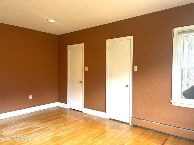 735 E 3rd St, Bloomsburg, PA 17815 - empty room featuring a baseboard radiator, light wood-style floors, and baseboards