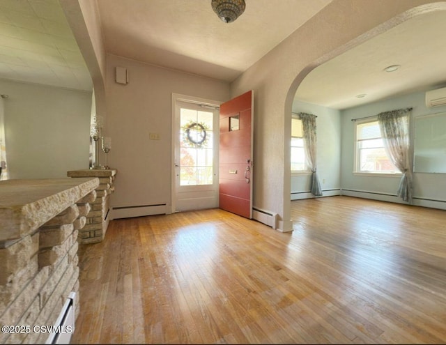 735 E 3rd St, Bloomsburg, PA 17815 - entryway featuring arched walkways, a baseboard heating unit, hardwood / wood-style floors, and a wall unit AC