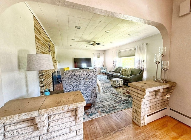 735 E 3rd St, Bloomsburg, PA 17815 - living area featuring wood finished floors, ceiling fan, a fireplace, arched walkways, and a textured wall