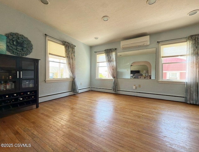 735 E 3rd St, Bloomsburg, PA 17815 - unfurnished living room with a wall mounted air conditioner and hardwood / wood-style flooring