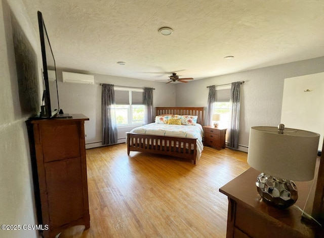 735 E 3rd St, Bloomsburg, PA 17815 - bedroom with a wall unit AC, multiple windows, light wood-type flooring, a textured ceiling, and ceiling fan