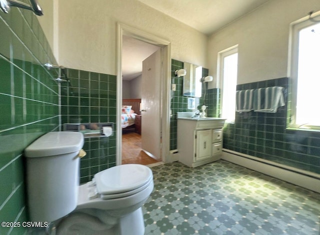 735 E 3rd St, Bloomsburg, PA 17815 - bathroom featuring tile walls, vanity, toilet, and a wainscoted wall