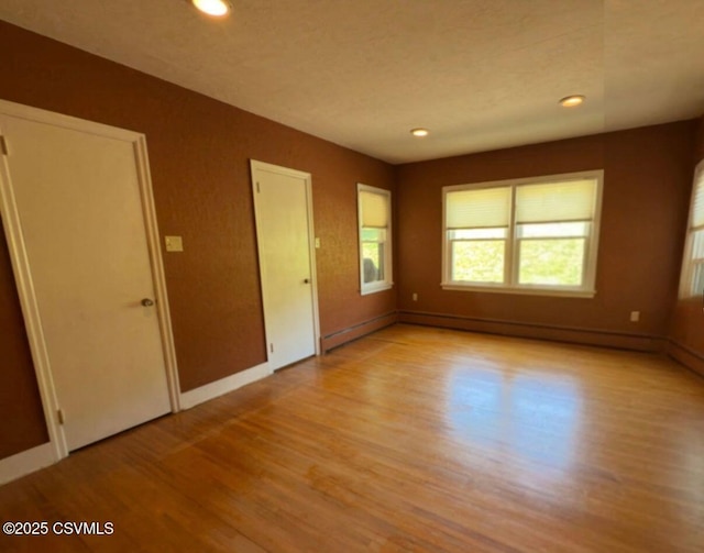 735 E 3rd St, Bloomsburg, PA 17815 - empty room with light wood-type flooring, baseboards, recessed lighting, and a baseboard heating unit