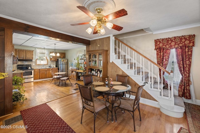 341 Dewart St, Danville, PA 17821 - dining space with light wood finished floors, stairs, a ceiling fan, a chandelier, and crown molding