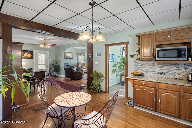 341 Dewart St, Danville, PA 17821 - dining area featuring light wood finished floors, a paneled ceiling, baseboards, ceiling fan, and a chandelier