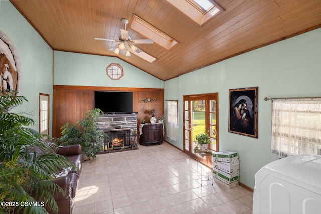 341 Dewart St, Danville, PA 17821 - tiled living room featuring a skylight, washer / clothes dryer, ceiling fan, a warm lit fireplace, and wooden ceiling