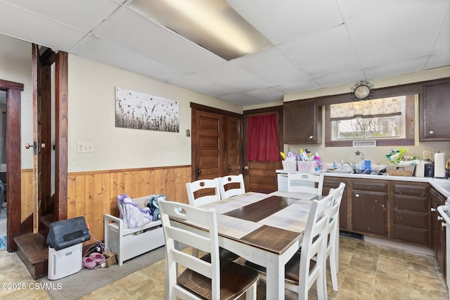 276 3rd St, New Columbia, PA 17856 - dining area featuring a drop ceiling, a wainscoted wall, wooden walls, and light stone finish floors