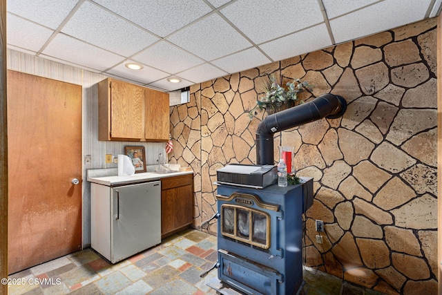 laundry area featuring a wood stove, recessed lighting, and light stone finish floors