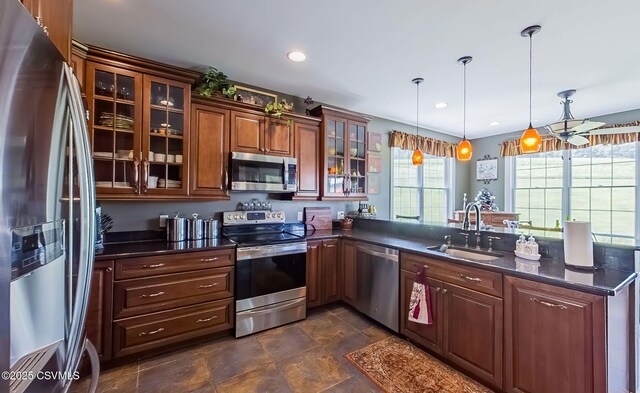357 Lick Run Rd, Bloomsburg, PA 17815 - kitchen with stainless steel appliances, a sink, a peninsula, decorative light fixtures, and glass insert cabinets
