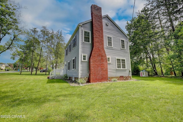 120 Geise St, Sunbury, PA 17801 - view of side of property with a chimney, a lawn, a storage unit, and an outbuilding