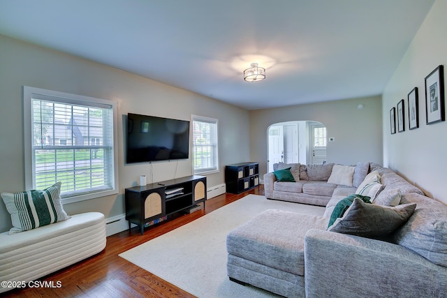 120 Geise St, Sunbury, PA 17801 - living room with a baseboard radiator, arched walkways, plenty of natural light, and dark wood-type flooring