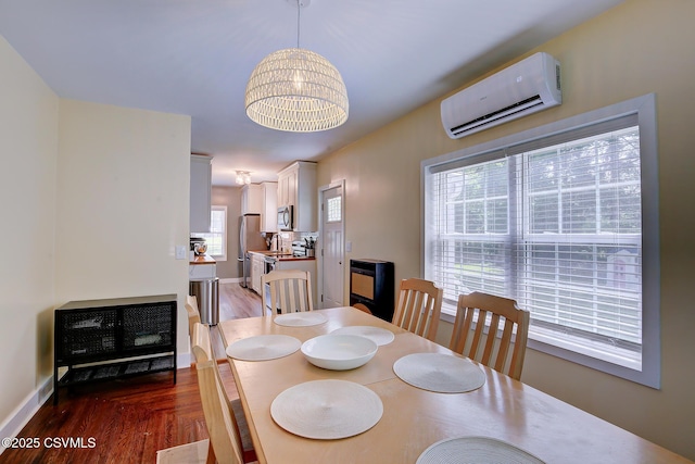 120 Geise St, Sunbury, PA 17801 - dining area with an AC wall unit, wood finished floors, baseboards, and a chandelier
