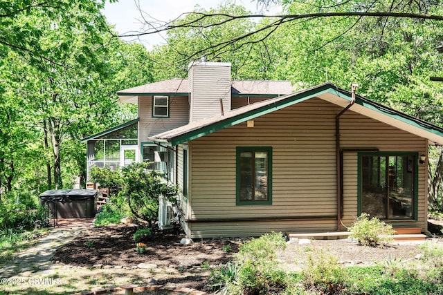 78 Trillium Ln, Danville, PA 17821 - back of house with a hot tub, a sunroom, and a chimney