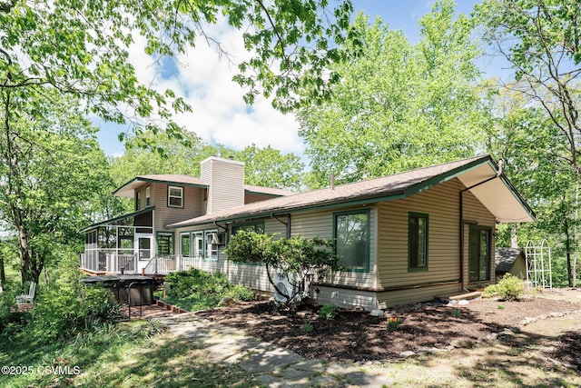 78 Trillium Ln, Danville, PA 17821 - rear view of house with a sunroom, a chimney, a wooden deck, and a shingled roof