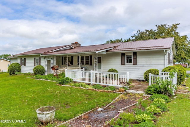 view of front of home featuring a front yard, a chimney, metal roof, and a porch