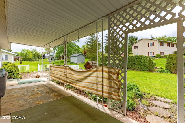 view of patio featuring a storage shed and an outbuilding
