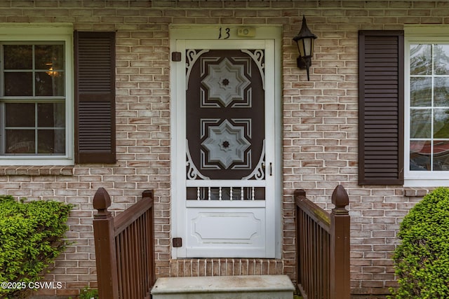 doorway to property featuring brick siding