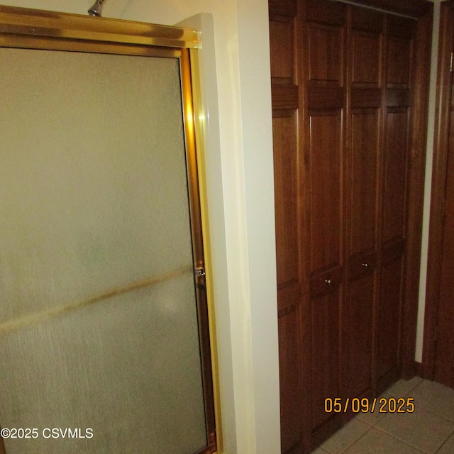 full bath with a stall shower and tile patterned floors