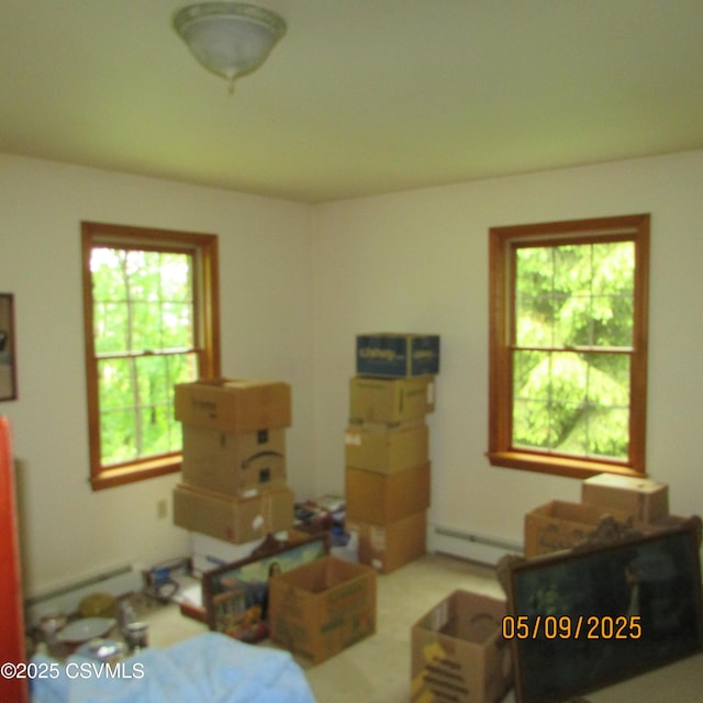 bedroom featuring baseboard heating and multiple windows