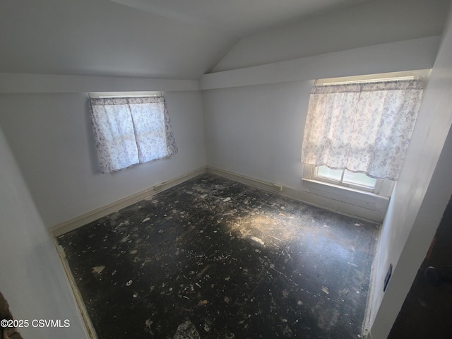 unfurnished bedroom featuring vaulted ceiling and multiple windows