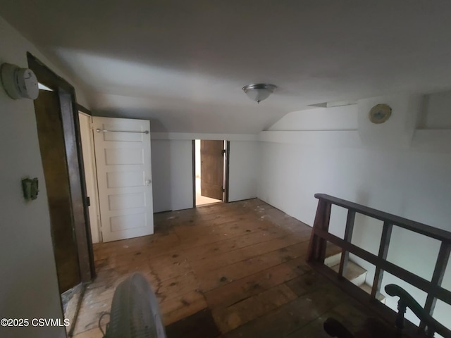 additional living space with lofted ceiling and hardwood / wood-style flooring