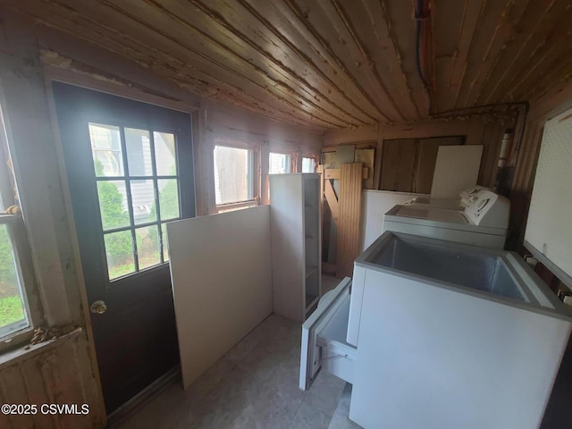 clothes washing area with healthy amount of natural light, washing machine and clothes dryer, and wood ceiling