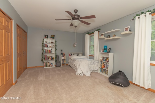 carpeted bedroom with a ceiling fan and baseboards