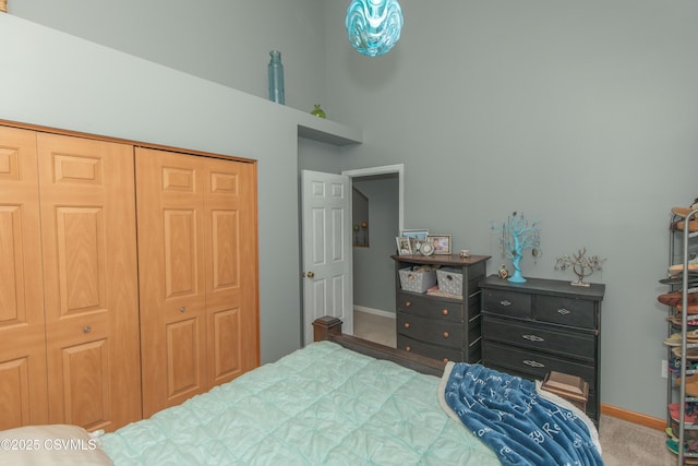 bedroom with carpet floors, baseboards, and a closet