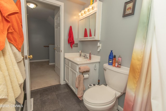 bathroom featuring toilet, vanity, and baseboards