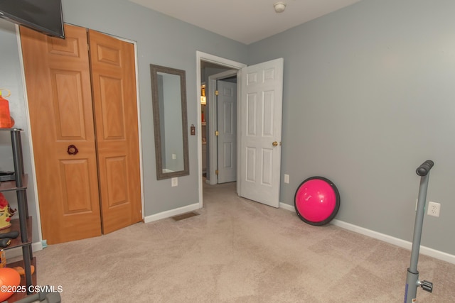 exercise room with carpet floors and baseboards