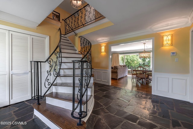 304 Hardscrabble Ln, Lewisburg, PA 17837 - staircase with stone tile flooring, a wainscoted wall, a decorative wall, ornamental molding, and a chandelier