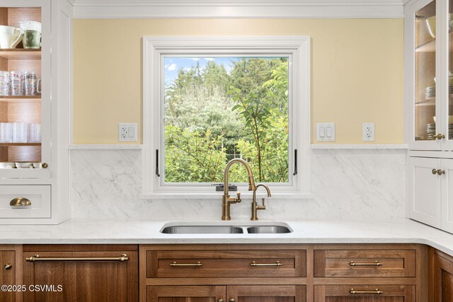 304 Hardscrabble Ln, Lewisburg, PA 17837 - kitchen featuring a sink, glass insert cabinets, brown cabinets, backsplash, and crown molding