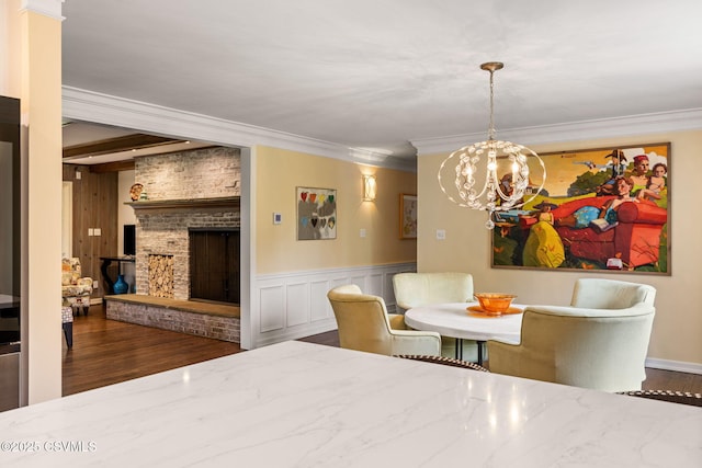 304 Hardscrabble Ln, Lewisburg, PA 17837 - dining room featuring a chandelier, crown molding, wood finished floors, a brick fireplace, and a wainscoted wall