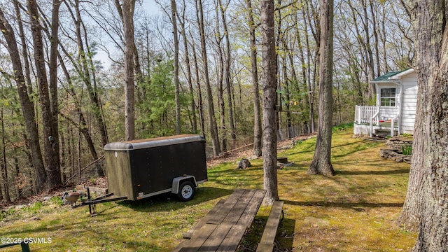 view of grassy yard featuring a forest view