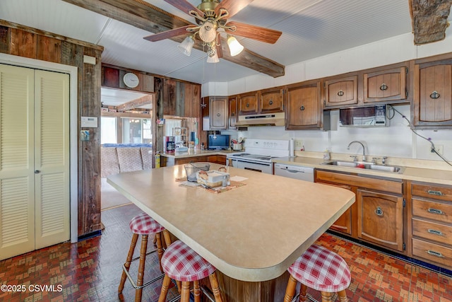 kitchen with white appliances, a sink, brick floors, light countertops, and wood walls