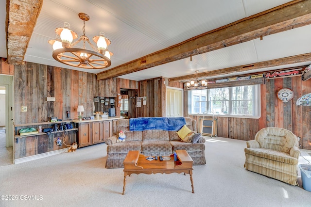 living area with a chandelier, wooden walls, light colored carpet, and beamed ceiling