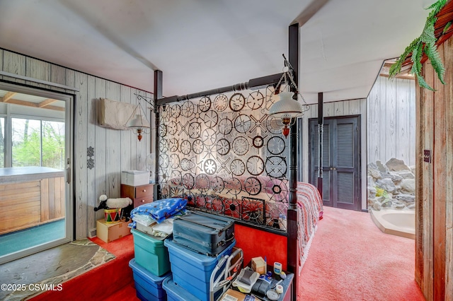 bedroom featuring wooden walls and access to outside