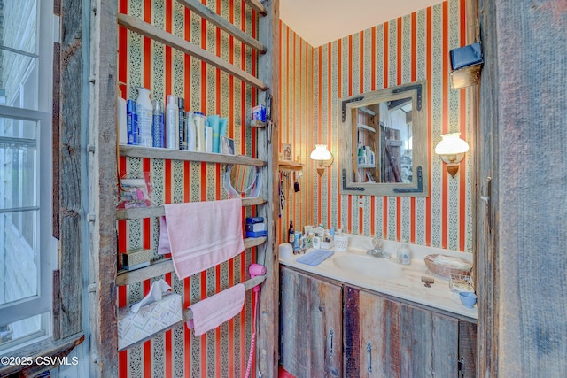 bathroom featuring wallpapered walls and vanity