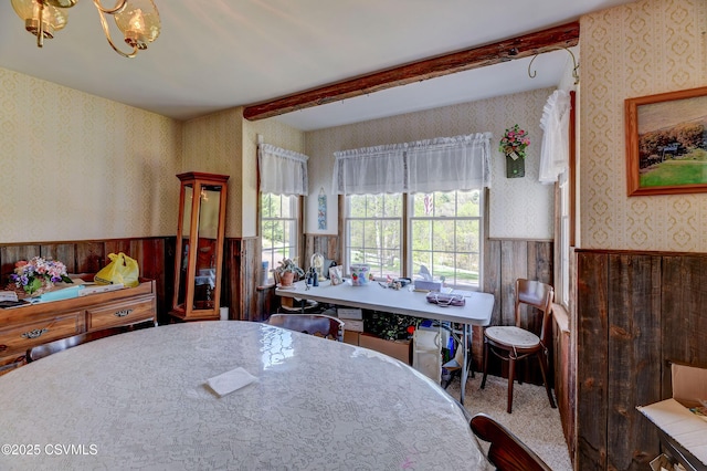 dining room featuring wallpapered walls, a wainscoted wall, beamed ceiling, and wooden walls