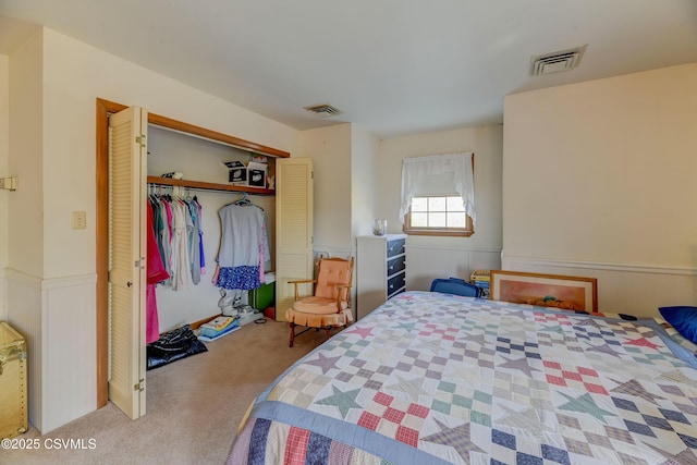 bedroom featuring carpet, a closet, and wainscoting
