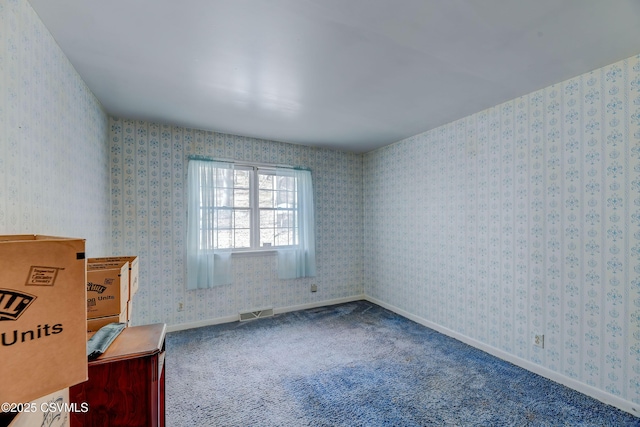 carpeted empty room featuring baseboards