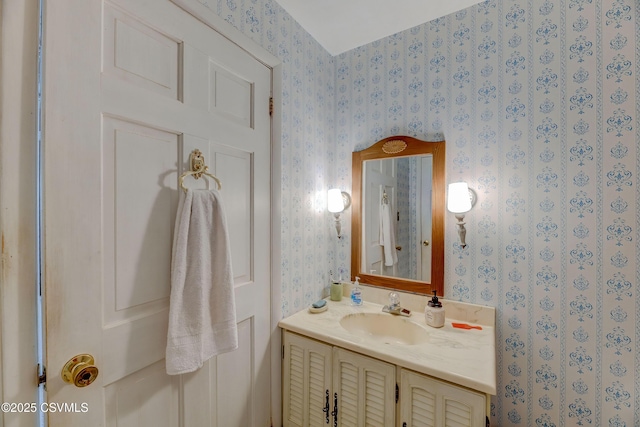 bathroom with wallpapered walls and vanity