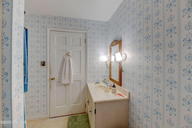 bathroom featuring wallpapered walls, vanity, tile patterned floors, and baseboards