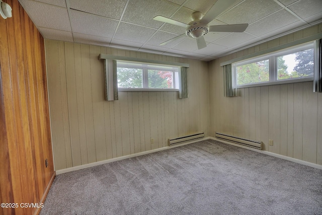 110 W 7 Th St, Mifflinville, PA 18631 - carpeted empty room with a baseboard heating unit, healthy amount of natural light, a ceiling fan, wood walls, and a baseboard radiator