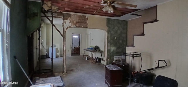 misc room with a ceiling fan, concrete flooring, arched walkways, and washer / clothes dryer