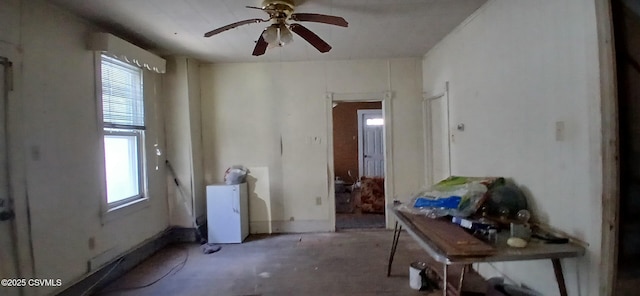 miscellaneous room with healthy amount of natural light, ceiling fan, and concrete flooring